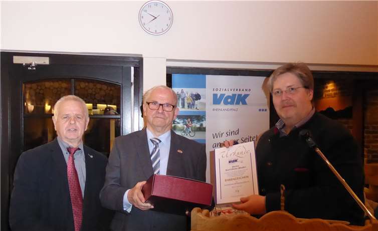 Karl Heinz Binder (Mitte) nimmt aus der Hand des Kreisvorsitzenden Heinz Wilhelm Schaumann (rechts) das Ehrenzeichen des VdK entgegen. Der 2. Vorsitzende Erich Ottersbach (links) gratuliert im Namen des Vorstands.