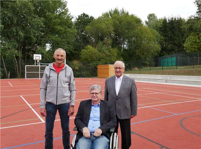 Karl Wiedenmann (Erster Vorsitzender des Sportvereins Holler), Ortsbürgermeister Uwe Meyer und Pfarrer Heinz Walter Barthenheier freuen sich, das neue Mehrzweckfeld den Bürgern von Holler zu übergeben.