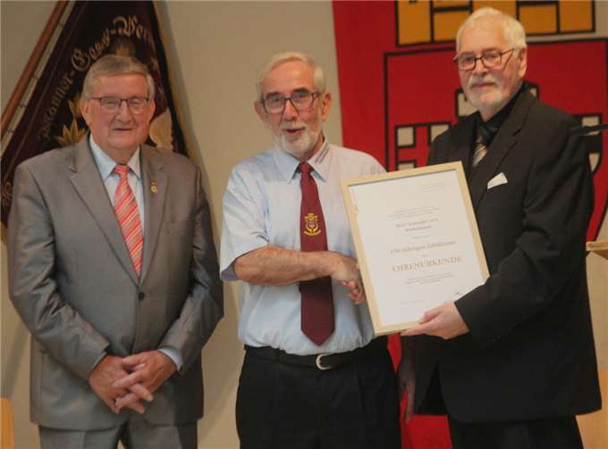 Karl Wolff und Karl-Heinz Müller übergeben die Ehrenurkunde an Leo Pickel.
