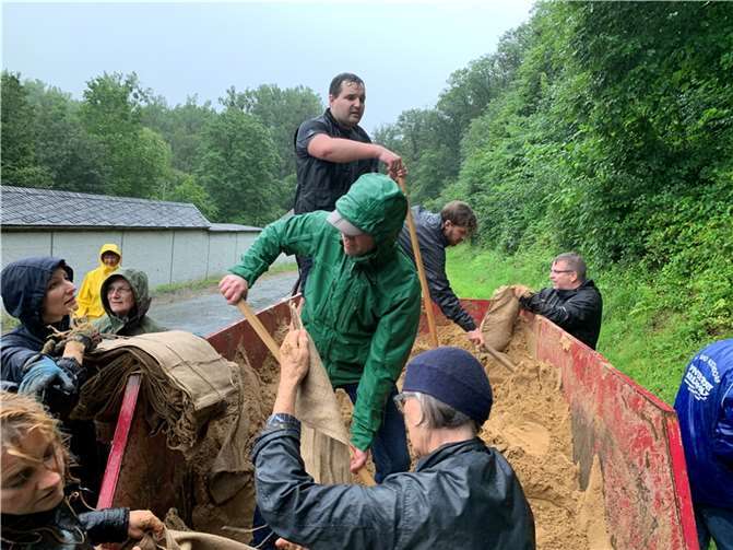 Flut: Gedanken in Worte fassen, auch wenn es Kraft kostet Karsten Janotta (stehend, in blauem T-Shirt) half am 14. Juli in Bad Bodendorf seinen Mitmenschen beim Befüllen der Sandsäcke. Foto:ROB