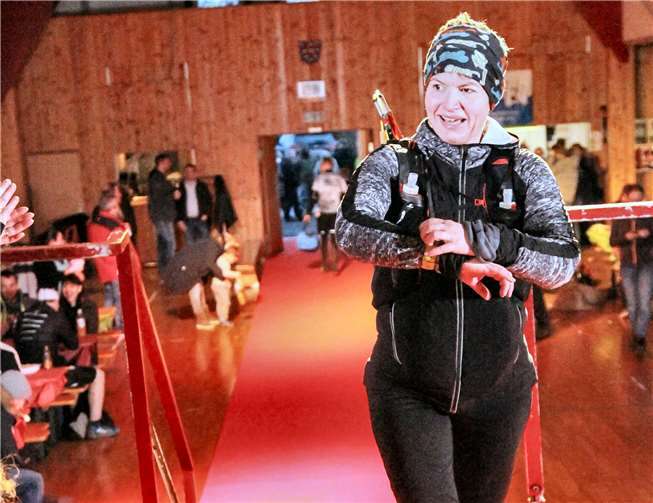Katja Dasbach beim Zieleinlauf des „Schinder-Trail Winterparadies“ auf der Bühne der Turnhalle in Holzhausen an der Haide. Foto: eventfotografie24.de
