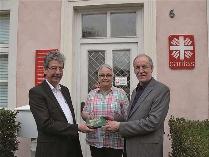 Katy Schug (Mitte) und Winfried Görgen (rechts) überreichen Alfred Steimers (links) zum Start in seine neue ehrenamtliche Tätigkeit als Vorsitzender des Caritasrats ein Buchgeschenk. privat