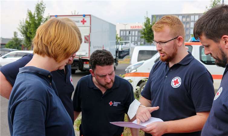 Kaum angereist und direkt in den Einsatz: Rotkreuzler aus dem münsterländischen Kreis Borken besprechen den ersten Einsatzauftrag und planen die Anfahrt in den zugewiesenen Einsatzabschnitt im Katastrophengebiet Ahr. Foto:Thorsten Trütgen