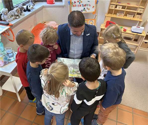 Kaum hatte der Bürgermeister das Buch aufgeschlagen, bildeten die Kinder auch schon einen neugierigen Kreis um Holger Jung. Foto: Stadt Meckenheim