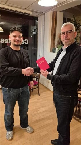 Kazim Akar erhält sein Parteibuch von Uli Bieber.  Foto: Wolfgang Latz