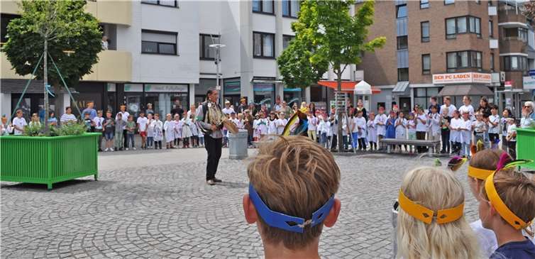 Kendall Old Elk trommelt und singt mit kleinen und großen Menschen auf dem Neuen Markt.