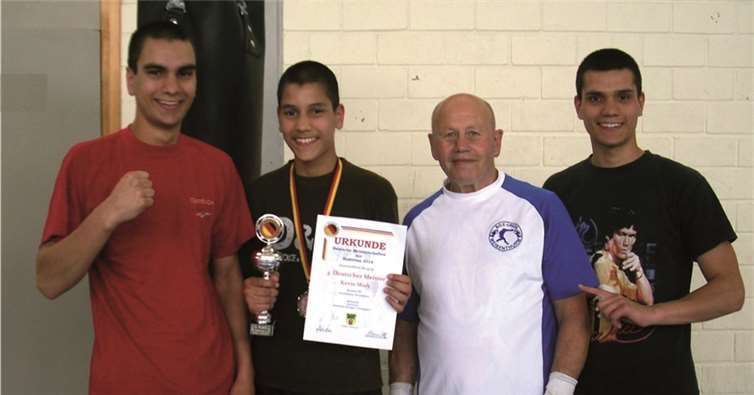 Kevin Miah (2.v.l.) mit seinen Brüdern Robert (1.v.l.) und Marvin (4.v.l.) und Trainer Heinrich Ottersbach. privat