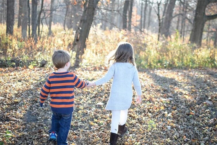 Kinder Hand in Hand im Wald