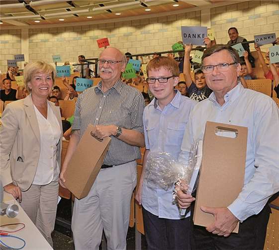 Kinder-Uni-Koordinatorin Inge Bitzer und der 14-jährige Schüler Sandro Hartel übergaben Prof. Dr. Reinhard Harzer und Prof. Dr. Hermann-Josef Schink zum Abschied ein Weinpräsent.  Privat