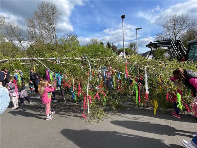 Kinder beim Schmücken des Maibaums.