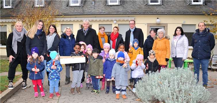 Kinder der Andernacher Kitas haben den Schmuck für die Weihnachtsbäume im Weihnachtsdorf gebastelt. Die Andernacher Sparda-Bank mit Filialleiter Henning Oster (hinten rechts) hat allen Mädchen und Jungs als Dank einen Schokoladenweihnachtsmann spendiert, wie hier in der Kita Läufstraße. Darüber freut sich auch Bürgermeister Claus Peitz (hinten links). Foto: Stadt Andernach/Maurer