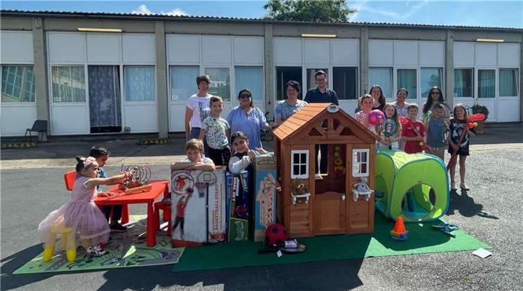 Kinder der Gemeinschaftsunterkunft und der Grundschule Freiherr-vom-Stein, Mitarbeiter:innen des Ordnungsamtes, Vertreter:innen der Schule und des Elternbeirates bei der Übergabe des Spielzeugs