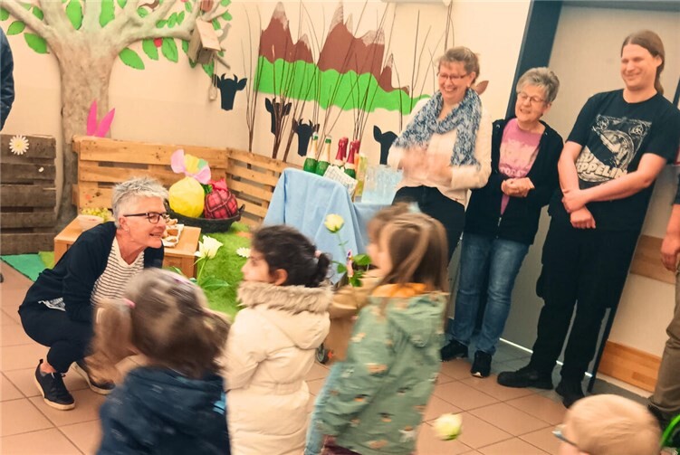 Kinder der Integrativen Kita verabschieden sich mit weißen Rosen von Brigitte Baumann.