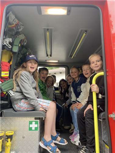 Kinder der Klasse 3 in einem Löschfahrzeug der Freiwilligen Feuerwehr.