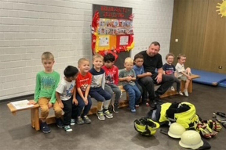 Kinder lernen die Feuerwehrausrüstung kennen