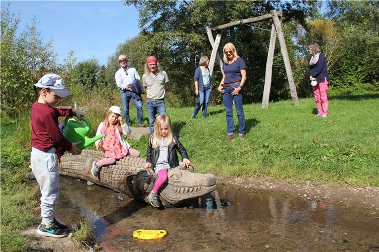 Kinder nehmen die Holzfiguren mit großem Interesse und viel Spaß an. Im Hintergrund von links: Stadtbürgermeister Rolf Jung, der Holz-Künstler Jens Röser, die stellv. KiTa-Leitung Dagmar Weber, die Vorsitzende der Bürgerliste Selters e.V. Gabriele Wolters und die KiTa-Leiterin Elke Pollatz.Foto: privat