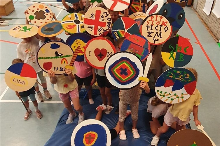 Kinder präsentieren ihre bunten Schilde und Schwerter