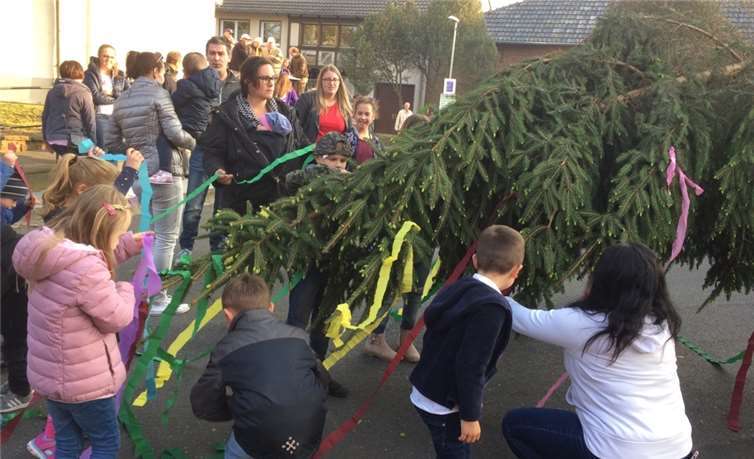 Kinder schmücken den Maibaum.