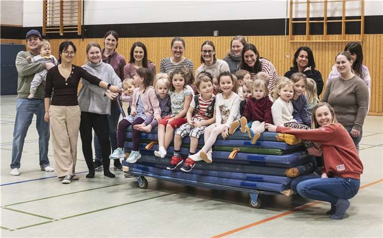 Kinder und Eltern freuen sich sichtlich über die neuen, farbenfrohen Matten. In der zweiten Reihe Angela Lessenich von der Bad Honnef AG (dritte von links), die das Eltern-Kind-Turnen von Lisa und Michael Lautwein (erste Reihe, dritte und vierter von rechts) nach der Spendenübergabe besuchte. Quelle: SV Rot-Weiß Rheinbreitbach