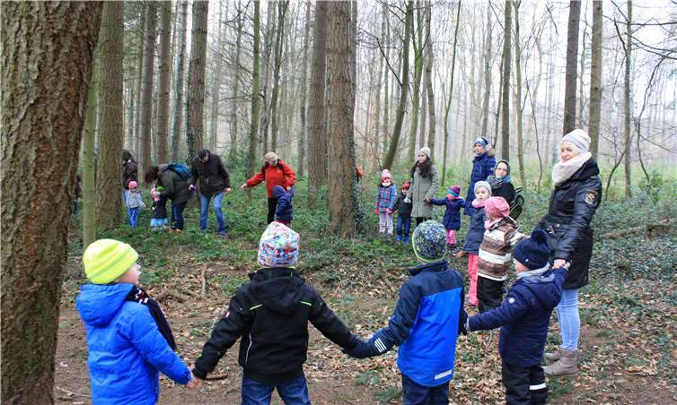 Kinder und Eltern umarmten in einer Menschenkette die Bäume des Waldes.  privat