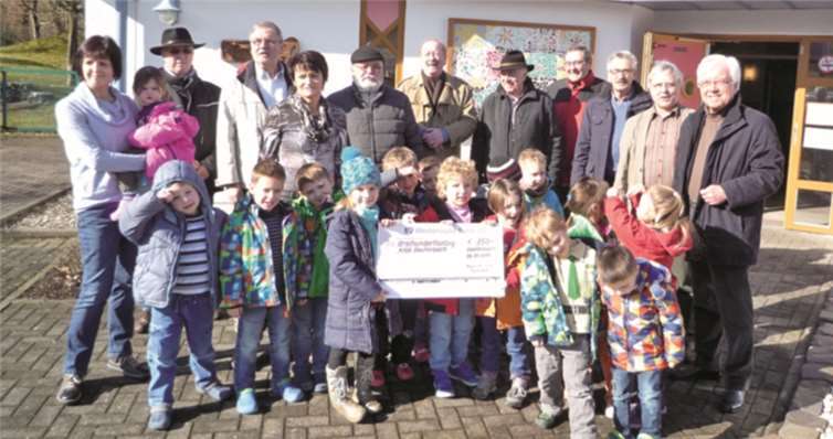 Kindergartenleiterin Dorothee Dutz freut sich zusammen mit den Kindern über den Spendenscheck des DorfStammtisches „55plus". privat