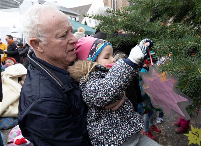 Kira schmückt mit ihrem Großvater den Baum.