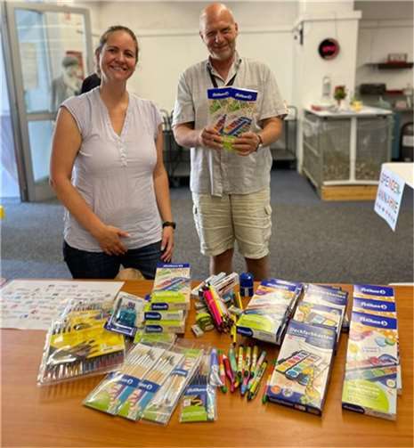 Kirsten Becker (Wirtschaftsjunioren Bonn/Rhein-Sieg überreicht Schulmaterialien aus der Aktion „Kauf1Mehr“ an Jan Erik Meyer (ZeSaBo).  Foto: Wirtschaftsjunioren Bonn/Rhein-Sieg