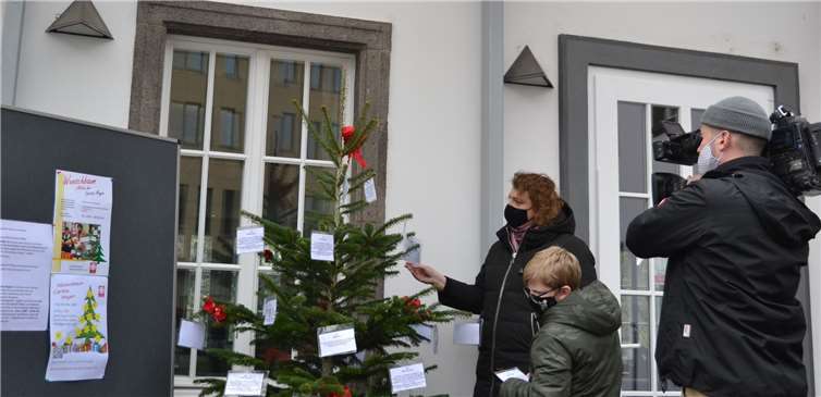 „Klappe, die Erste!“ Marc und Maria pflücken die ersten Wünsche vom Caritas-Wunschbaum. Schnell war die Aufnahme im Kasten. Foto: E.T. Müller