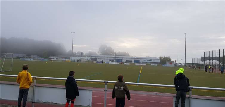 Klassen 1a und 1b beim Laufen, ihre Patenklassen feuern an.