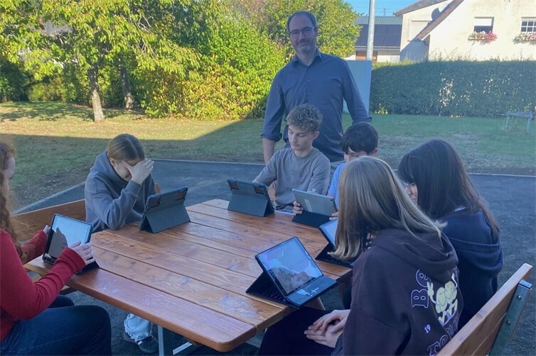 Klassenleiter der 8a,  Herr Andre Müller mit seiner Klasse beim Arbeiten im Freien