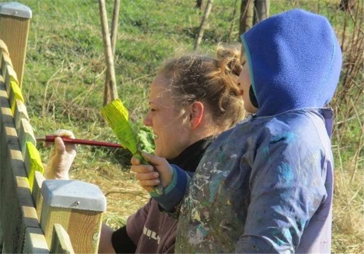 Klein und Groß halfen dabei, dem neuen Zaun einen bunten Anstrich zu verpassen.