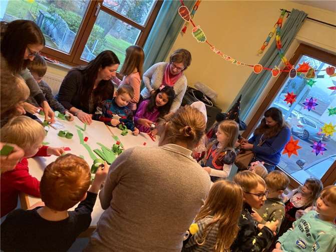 Kleine und große Zuschauer des Kamishibais beim Basteln der gefräßigen Raupe.