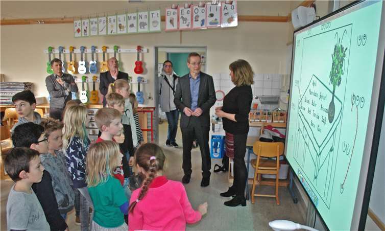Kleiner Plausch vor dem Whiteboard: Andreas Geron, Schulleiterin Claudia Mercer und die Grundschüler aus Bad Bodendorf mit der neuen Technik. Foto: BL
