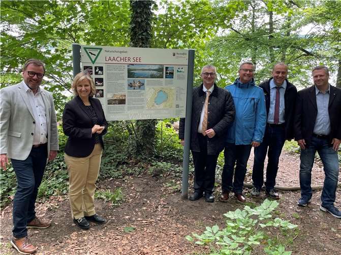 Klimaschutzministerin Katrin Eder (2. v. li.) und SGD-Nord-Präsident Wolfgang Treis (li.) enthüllten mit Dr. Alexander Saftig (4. v. re., Landrat des Landkreises Mayen-Koblenz), Horst Gies (3. v. re., Erster Kreisbeigeordneter des Landkreises Ahrweiler), Johannes Bell (2. v. re., Bürgermeister der VG Brohtal) und Steffen Steckbauer (re., Geschäftsführer der Klosterbetriebe Maria Laach) die neuen Infotafeln am Laacher See. Foto: SGD Nord