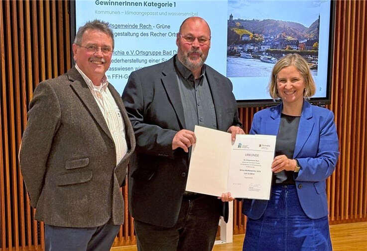Klimaschutzministerin Katrin Eder überreichte Rechs Ortsbürgermeister Thomas Hostert (Mitte) und dem Beigeordneten Gerhard Schreier im Rahmen des Klima-Wettbewerbs des Kommunalen Klimapakts Rheinland-Pfalz die Auszeichnung in der Kategorie „Kommunen – klimaangepasst und wassersensibel“. Foto: Angelika Görres