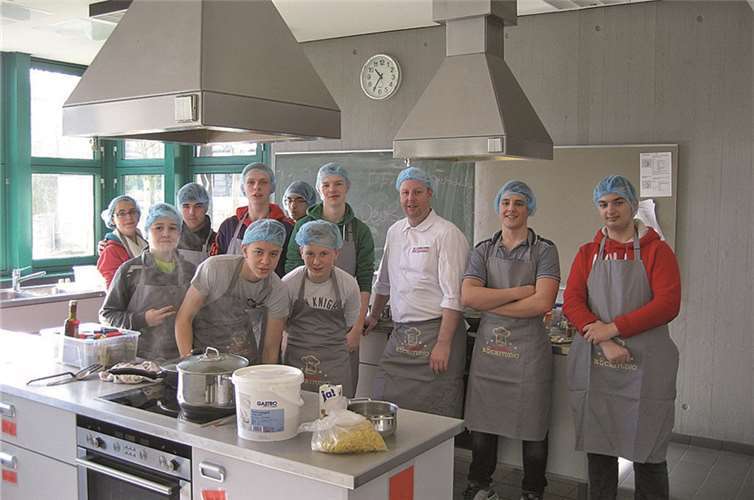 Koch Lukas Kokott beim Kochkurs in der Lehrküche der Schule.