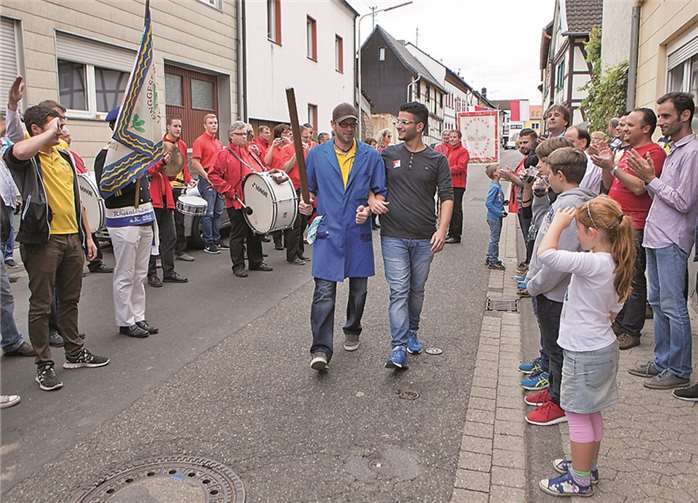 König Sebastian Rick schnappte sich beim Trinkzug am Kirmesmontag einen der jungen syrischen Flüchtlinge, die derzeit im Flüchtlingswohnheim untergebracht sind, zur obligatorischen Parade.