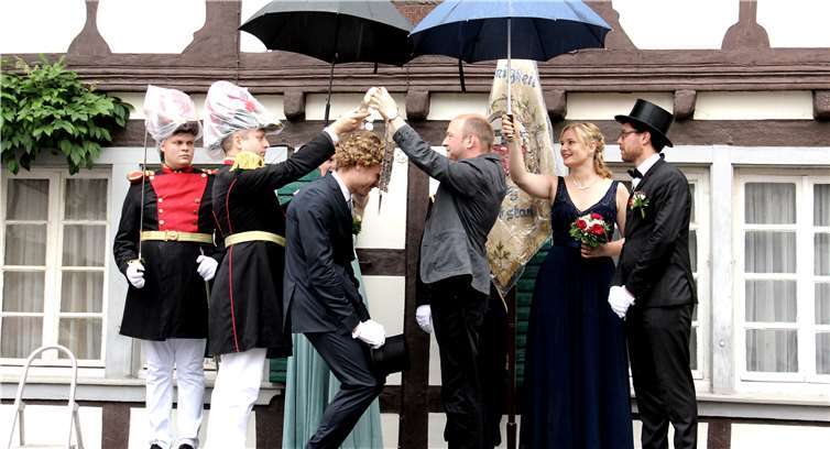 Königsschwester Marion und Königin Nadja schützten Tobias Wallek und Pfarrer Michael Ottersbach bei der Kettenübergabe vor dem Regen.
