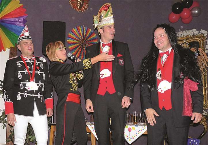 Komiteepräsidentin Karin Diensberg präsentiert das Mendiger Dreigestirn Peter Schlaus (designierter Prinz, mitte), Florian Stoll jun. (designierter Bauer, l.) und Thorsten Barthelmeh (designierte Jungfrau, r.).