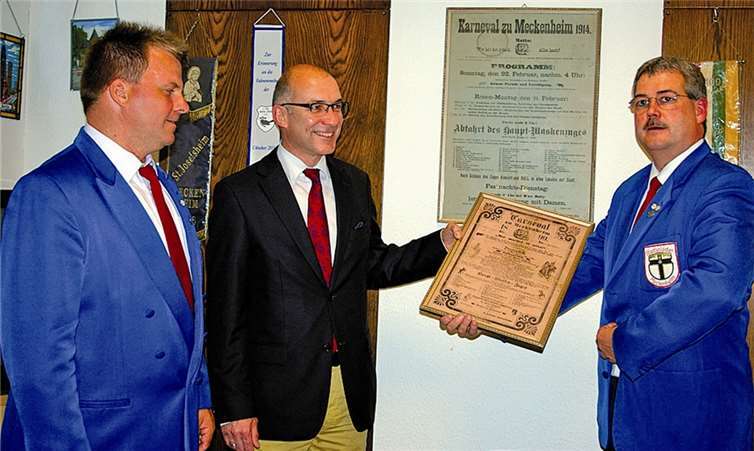 Kommandant Peter Klee, Bürgermeister Bert Spilles und Spieß Peter Siegberg präsentieren ein Plakat von 1899.
