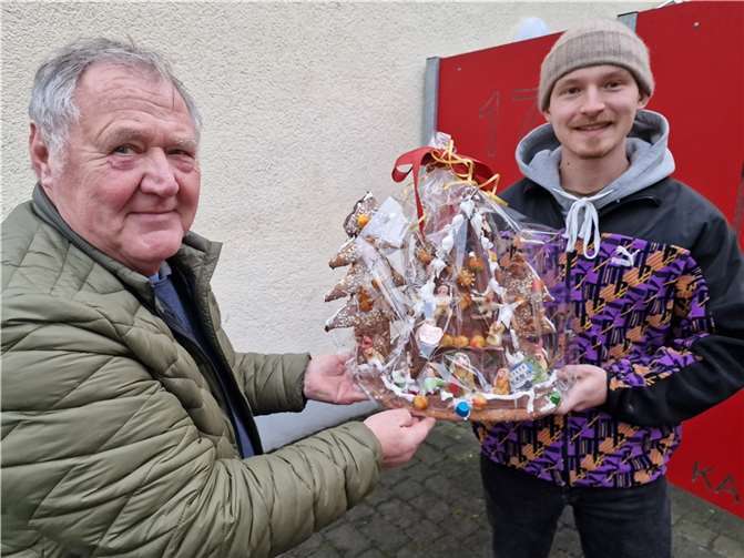 Konditormeister Gerhard Ziegler (l.) übergab das aufwändig gestaltete Lebkuchen-Hexenhaus an Ole Walczyk, Gruppenpädagoge in der Mädchen-Wohngruppe Kasbach.  Foto: Andreas Winkelmann