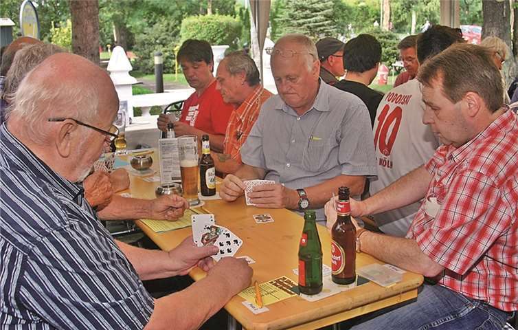 Konzentrierte Gesichter beim Karten spielen.RÜ
