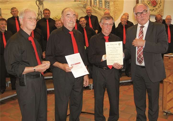 Kreischorleiter Wilfried Schäfer (rechts) ehrte zusammen mit dem Vorsitzenden Paul van Duinen (links) zwei langjährige Sänger: Dieter Adams (25 Jahre, 2. v.re) und Paul Theobald (50 Jahre, 2. v.l).