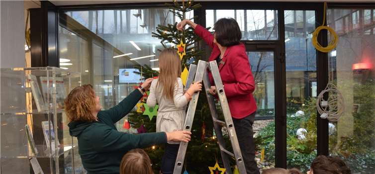 Kreisdirektorin Annerose Heinze beim Unterstützen der kleinen Weihnachtsbaumschmückerinnen und Weihnachtsbaumschmücker.