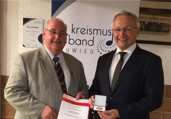 Kreismusikverbandsvorsitzender Achim Hallerbach (r.) gratuliert Hermann-Josef Esser und überreicht ihm die besondere Auszeichnung der Bundesvereinigung Deutscher Musikverbände.  Kreismusikverband Neuwied