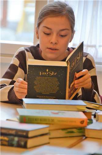 Kreissiegerin Jule Liess aus Rheinbach macht ihrem Namen alle Ehre und liest sich in der Vorbereitung auf den Wettbewerb durch bemerkenswerte Bücherstapel.  Foto: Gerd Engel