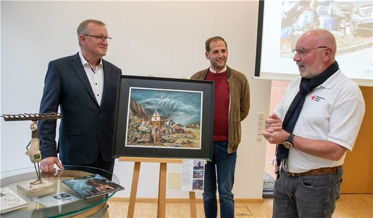 Künstler Eberhard Marx (re.) hatte die Idee zur Wohltätigkeitsversteigerung, die von Auktionator Julian Schmitz-Avila (Mitte) geleitet wird. Die Ausstellung mit den 14 zu Versteigerung stehenden Werken eröffnete der Grafschafter Bürgermeister Achim Juchem jetzt in Ringener Rathaus. Foto: -JOST-