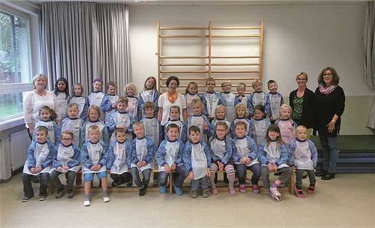 Kundenberaterin Melanie Dreißigacker (M.) überreichte die Malkittel an die Erstklässler, die sich mit der Grundschulrektorin Claudia Mercer (r.) und den beiden Klassenlehrerinnen Manuela Bauer (l.) und Ute Moskopp (2.v.r.) über die kleine Aufmerksamkeit sehr freuten. privat