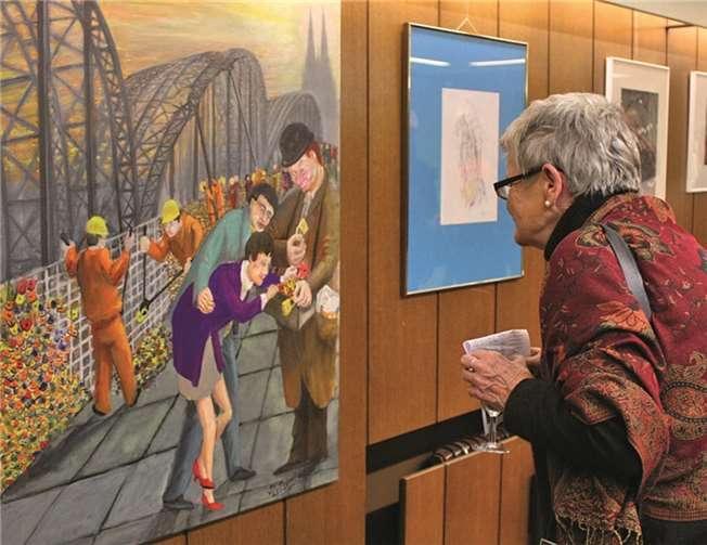 Kunstkreis-Mitglied Gudrun Rosenberg betrachtet Willi Zettelmeiers Bild „Seufzerbrücke“, in dem dieser das Phänomen von Liebesschlössern auf Brücken zum Thema macht.