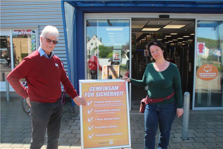 Kurt Queckenberg (hier mit einer Kundin vor seinem Elektrofachmarkt) ist mit den ersten Verkaufstagen nach der Corona-Sperre sehr zufrieden. Vor dem Eingang gibt es Sicherheitstipps, im Eingangsbereich ein Desinfektionsmittel für die Hände. Fotos: KMI